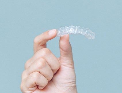 Closeup of patient holding clear aligner