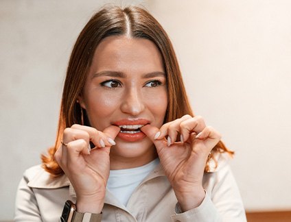 Patient putting on clear aligner in treatment room