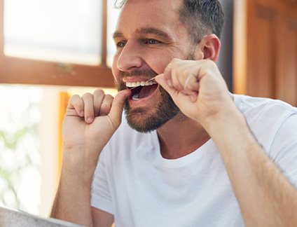 Closeup of man smiling while flossing
