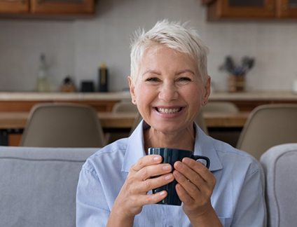 Woman smiling and holding a mug of coffee