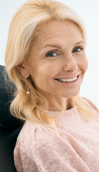 Patient smiling with a fully restored smile after All-on-4 dental implant treatment