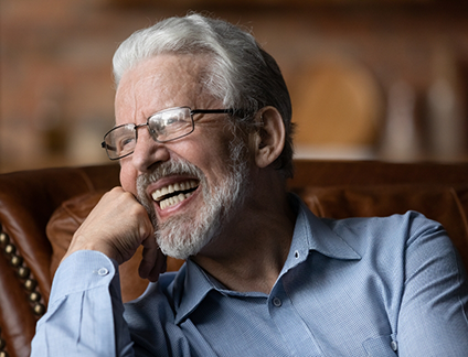 Patient smiling confidently after receiving All-on-4 dental implants