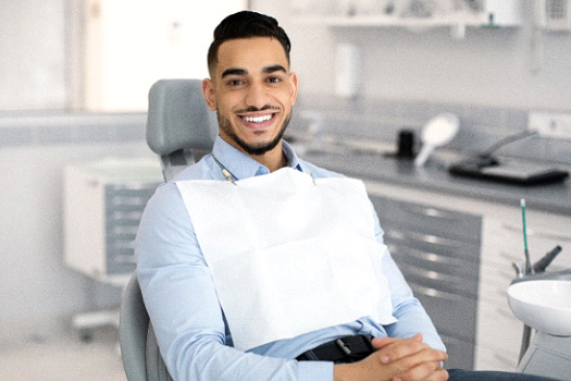 Patient smiling while sitting in treatment chair