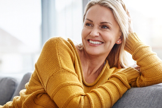 Woman smiling while relaxing on couch