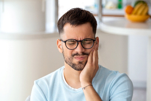 Man struggling with toothache at home