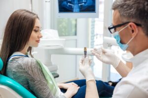Woman learning more about dental implants at consultation
